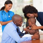 african mother and her son in doctor’s office with doctor and nurse